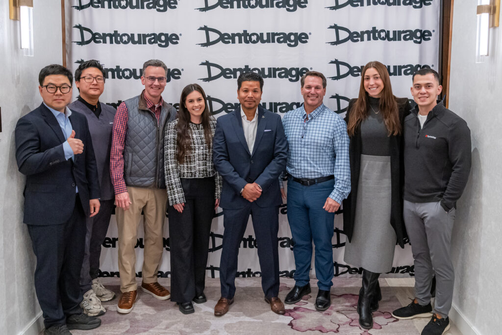 Group of people standing in front of banner.